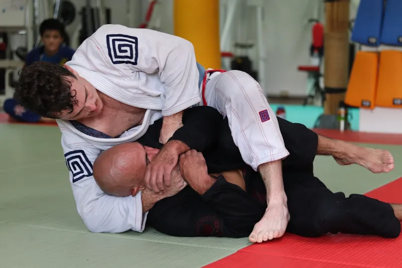 Two BJJ practitioners grappling during jiu jitsu training class