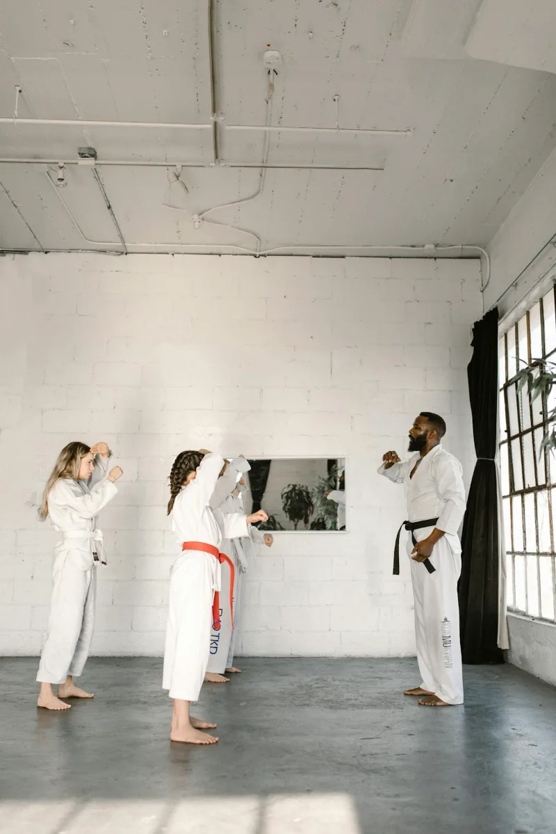 Martial arts instructor teaching self defense techniques to students in a training class