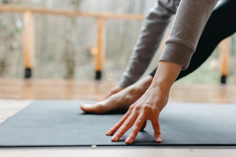Martial arts practitioner performing mobility and flexibility training at home as part of a conditioning routine