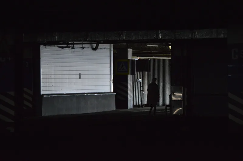 Person walking through a parking area at night staying aware of surroundings for personal safety