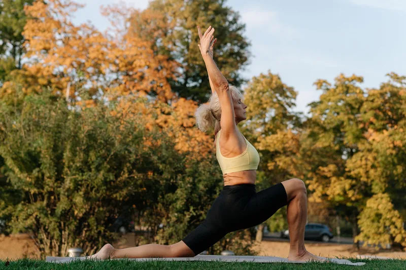 Senior tai chi practitioner performing slow deliberate movements from the simplified 24 form in a park