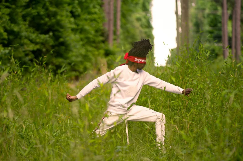 Tai chi practitioner demonstrating the single whip posture from the 24 form in outdoor practice