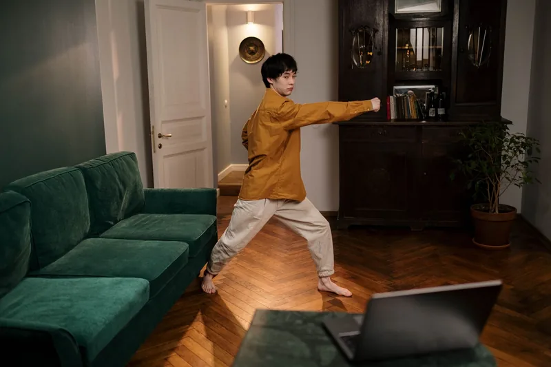 Person practicing tai chi at home in a quiet living room space