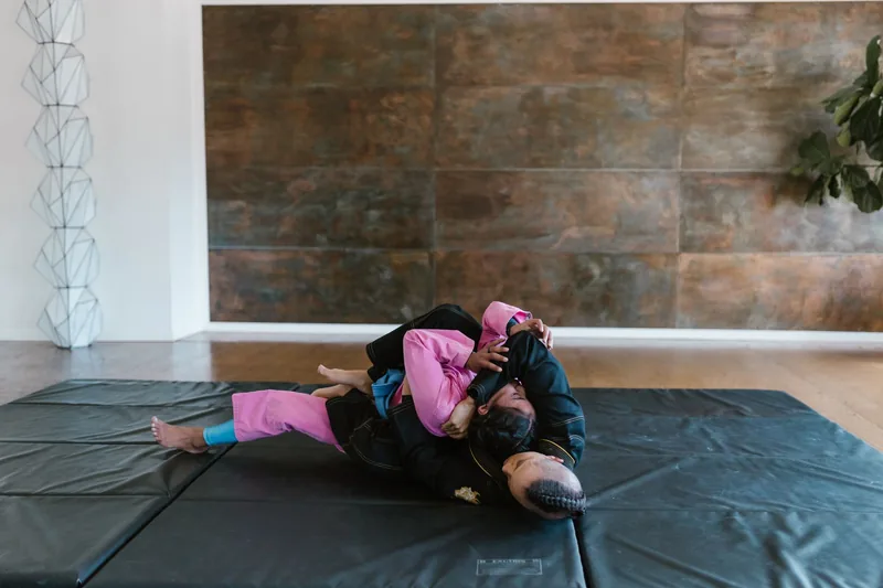 Beginners drilling basic BJJ techniques and ground positions on the mat