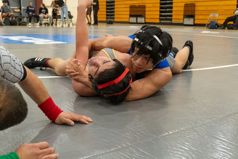 Wrestler shooting a takedown, illustrating the takedown focus in BJJ vs wrestling