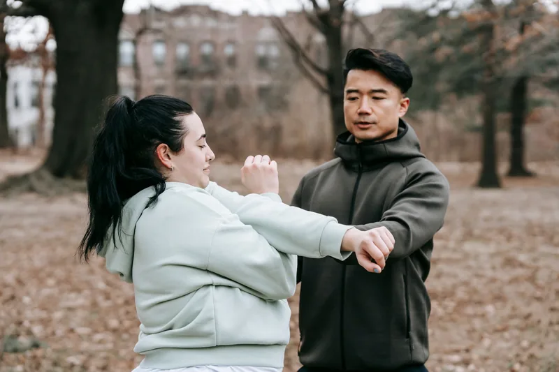 Instructor teaching Wing Chun close-range trapping technique and centerline guard to a student