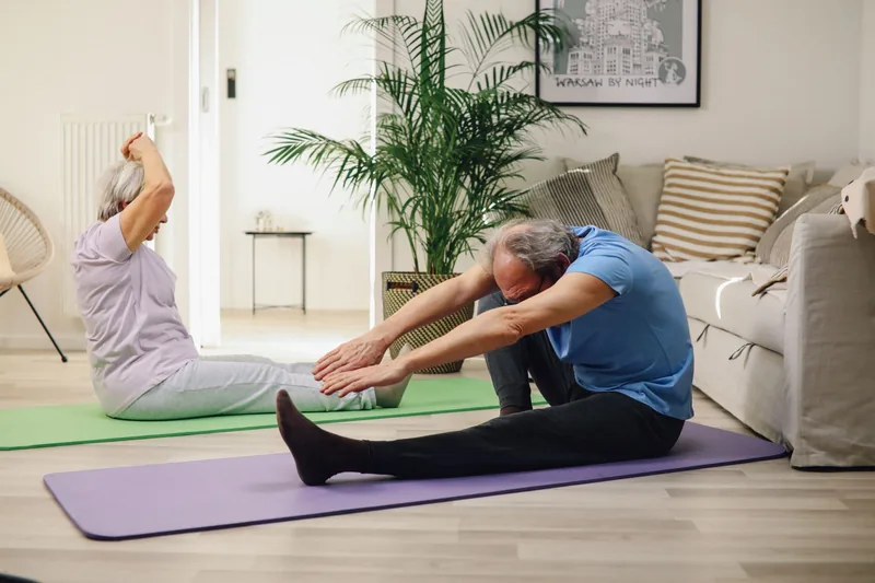 Couple practicing gentle tai chi at home to maintain joint mobility with arthritis