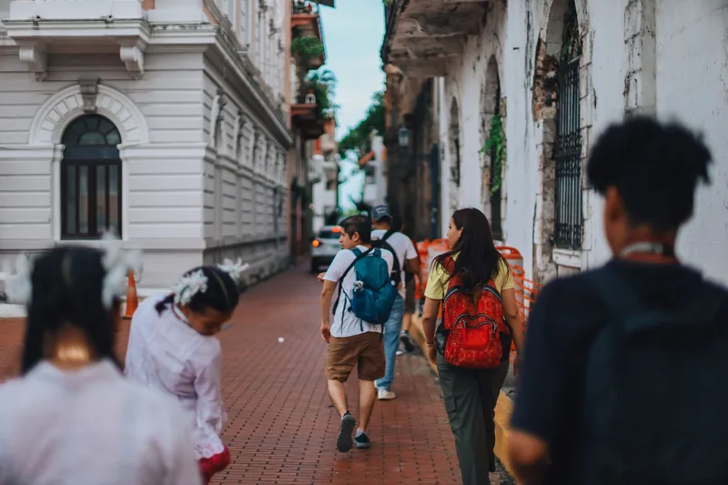 Tourist checking directions on a busy street while staying aware of surroundings for travel safety