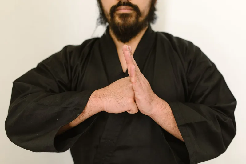 Kung fu practitioner holding hands at the centerline — the hand shapes trained in the Wing Chun forms