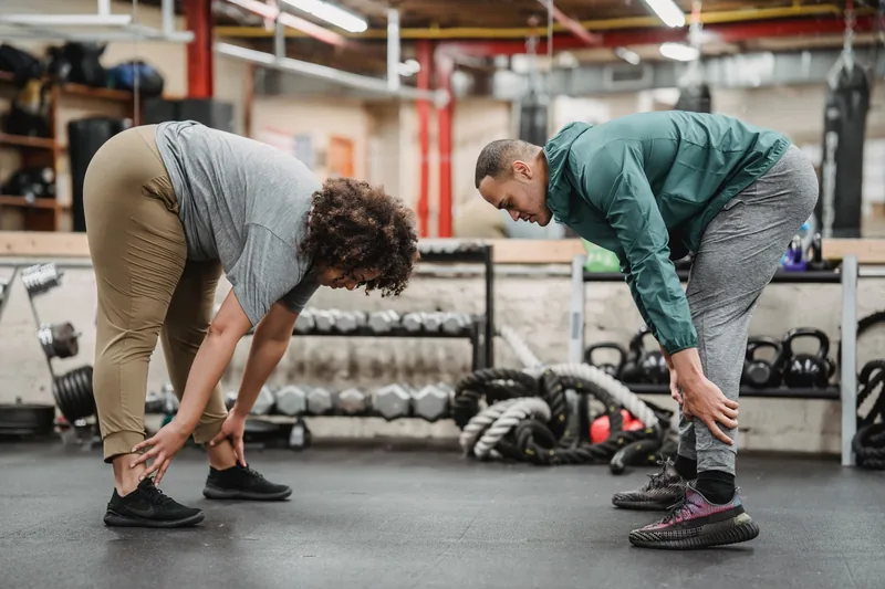 Two students warming up before class with a BJJ mobility routine