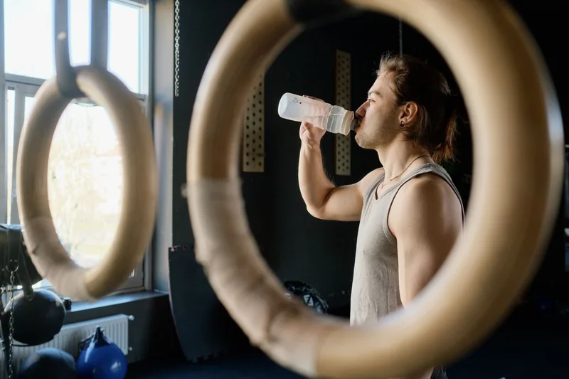 Athlete drinking water between sessions to stay hydrated for BJJ training