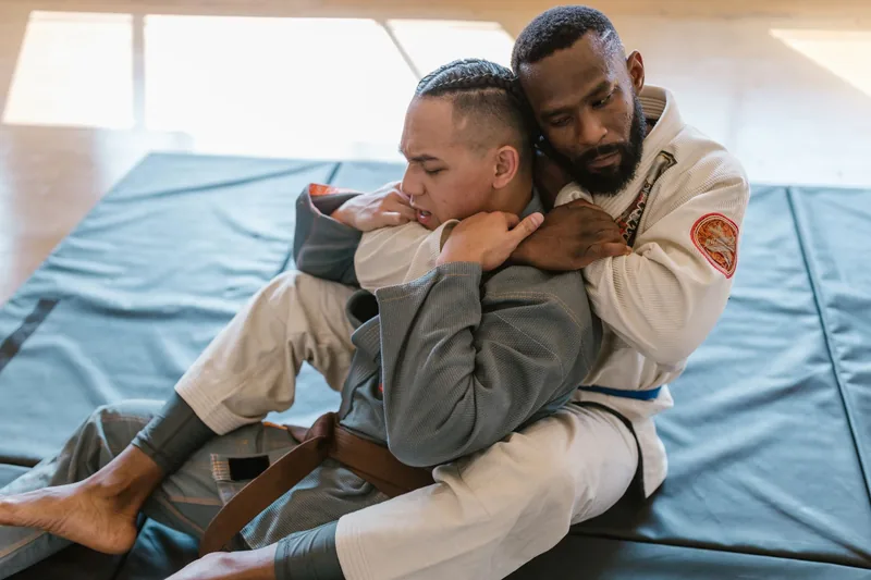 Adult students training jiu jitsu self defense techniques at a martial arts school