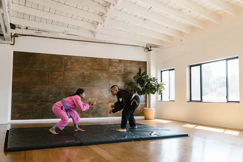 Two martial artists closing distance on the mat, the grappling range where HapKiDo joint locks and throws happen